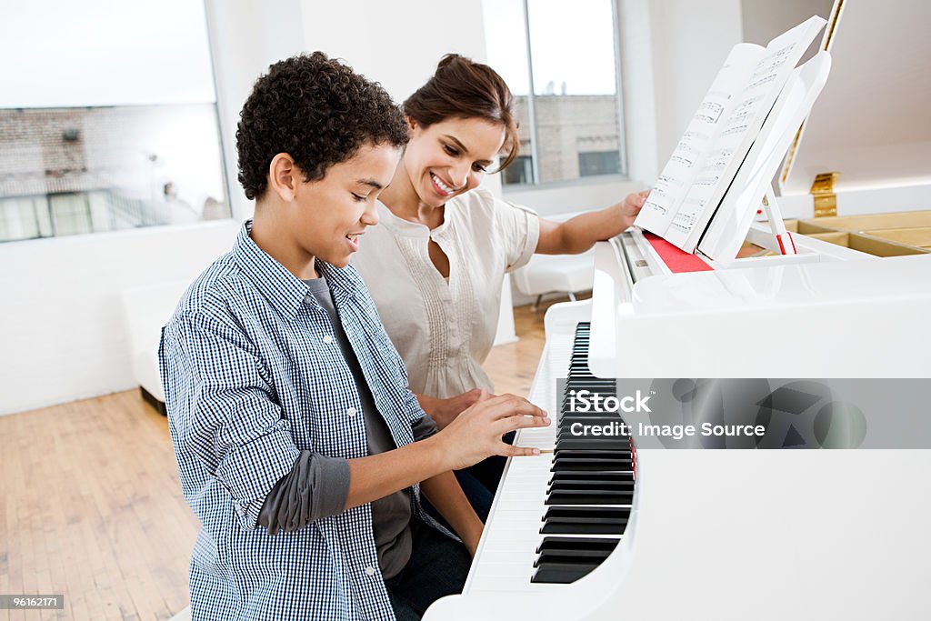 piano techer and student 
sitting at a paino